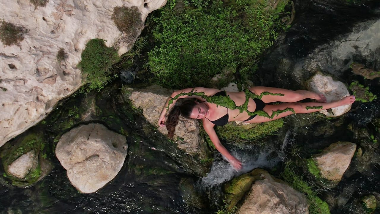 Traveller floating in a green wadi pool