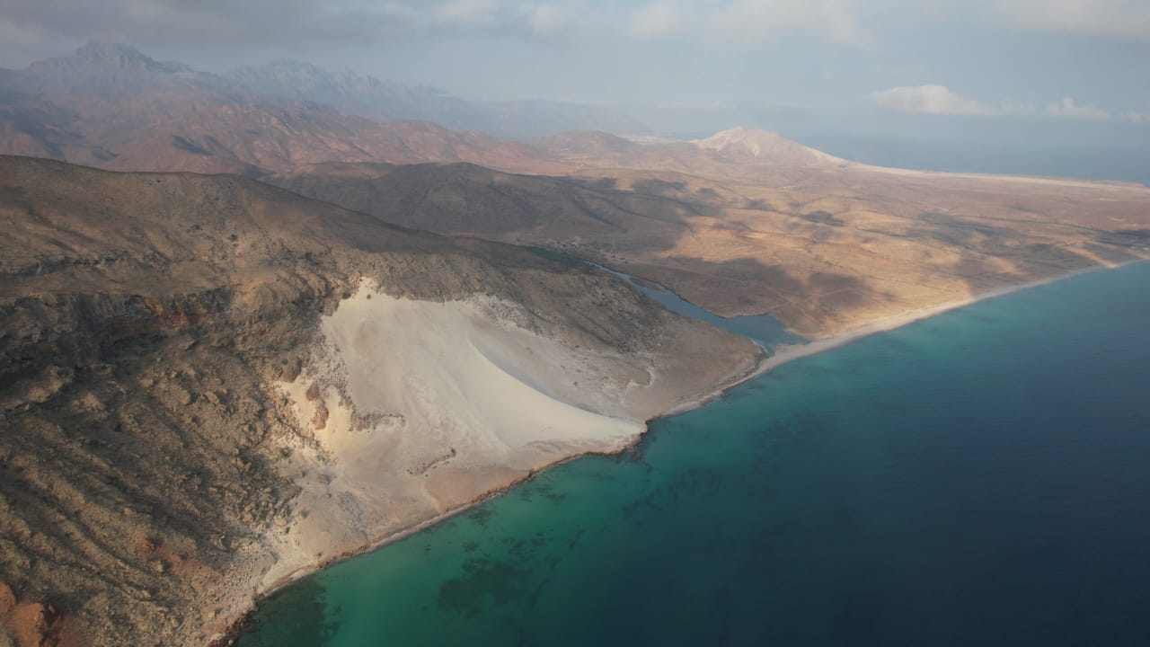 Aerial coastline with dunes and mountains
